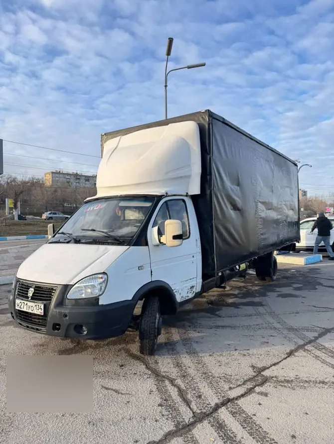 Белый грузовой автомобиль семейства ГАЗель с высоким тентованным кузовом; видны следы эксплуатации грузовой машины.
