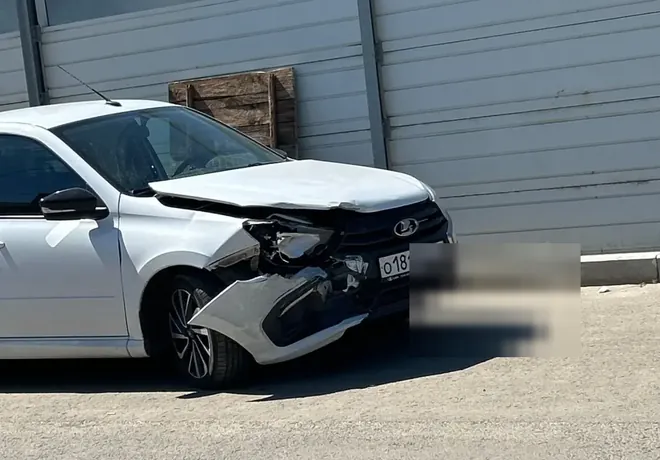Белая Lada Granta с повреждённым передним углом и нарушенными зазорами кузова.