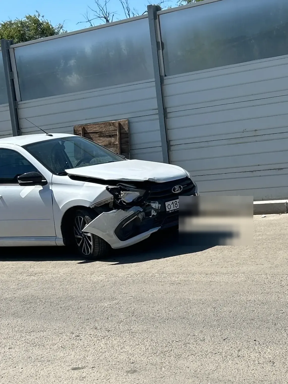 Белая Lada Granta с повреждённым передним углом и нарушенными зазорами кузова.