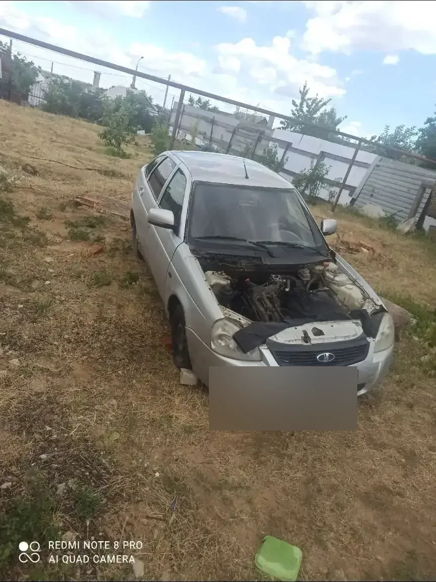 Серебристая Lada Priora: моторный отсек открыт, двигатель на фотографии отсутствует.