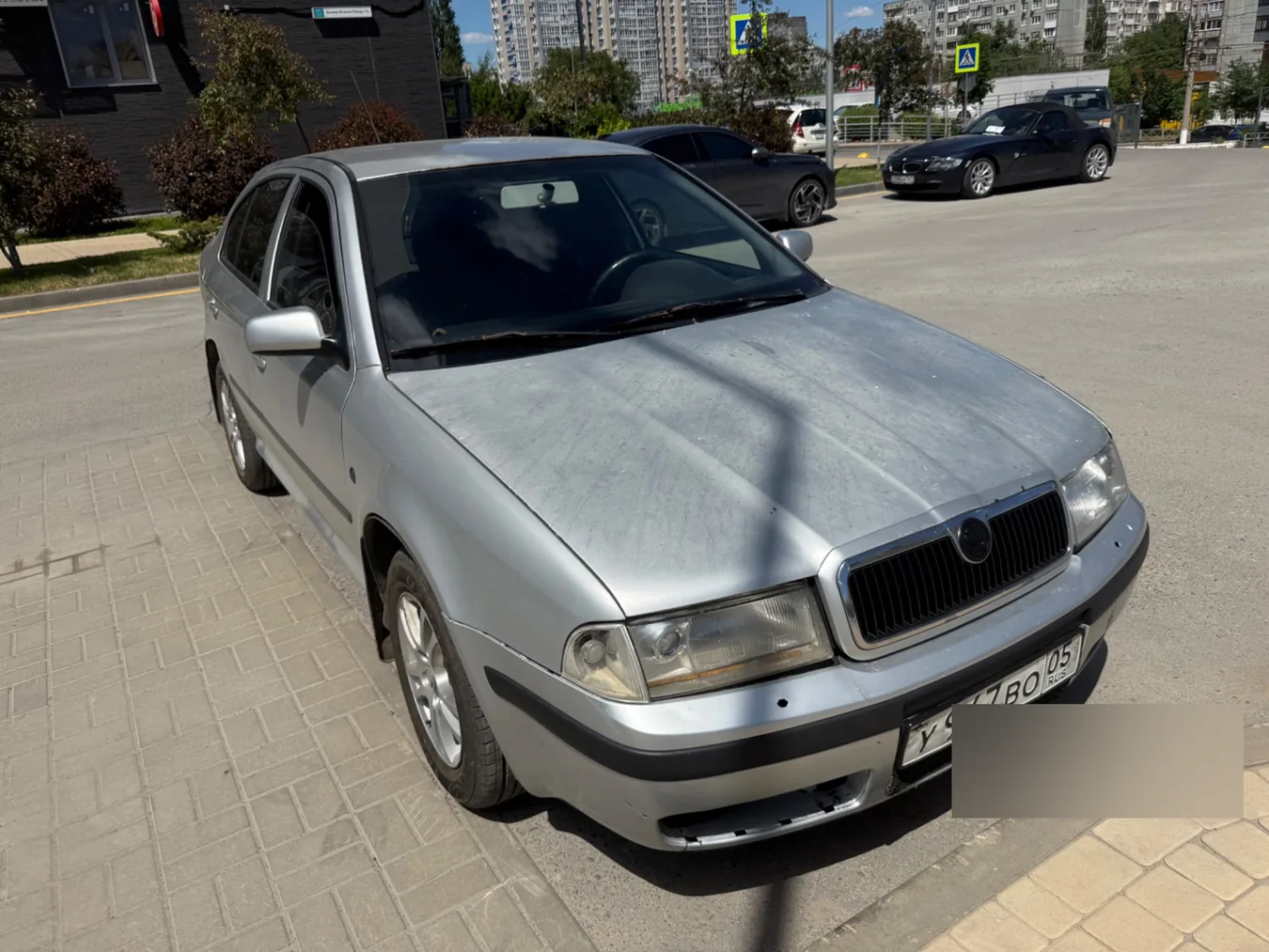 Серебристая Skoda Octavia с видимыми эксплуатационными следами на лакокрасочном покрытии и переднем бампере.