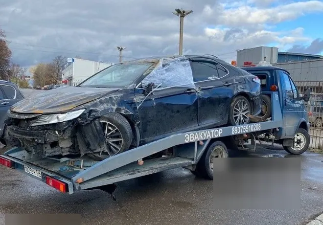 Тёмная Toyota Camry с повреждениями передней и боковой частей уже размещена на эвакуаторе.