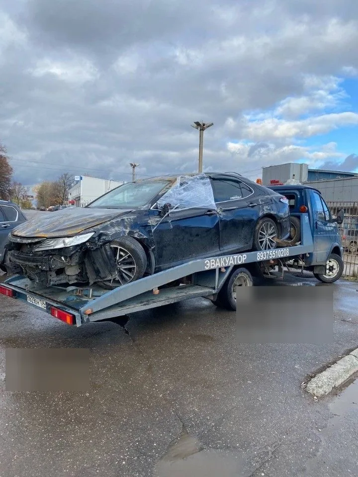 Тёмная Toyota Camry с повреждениями передней и боковой частей уже размещена на эвакуаторе.