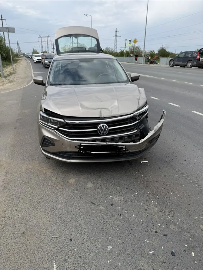 Светлый Volkswagen Polo с деформированным капотом, повреждённым передним бампером и смещёнными кузовными деталями.